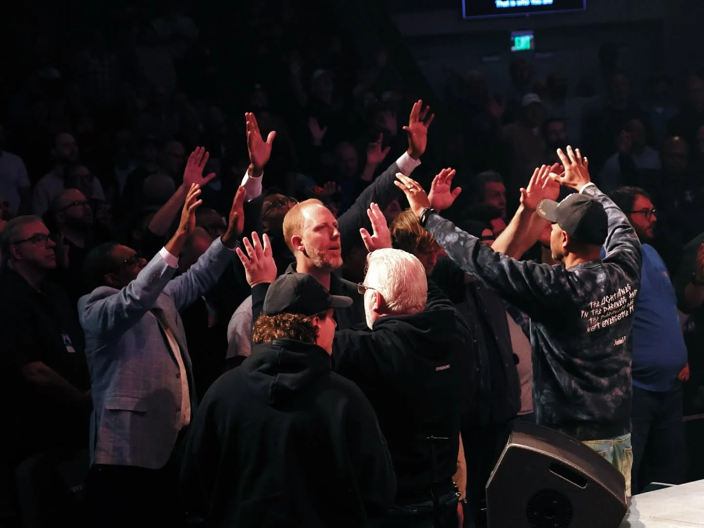 Men gathering in prayer and encouragement at Invincible 2026