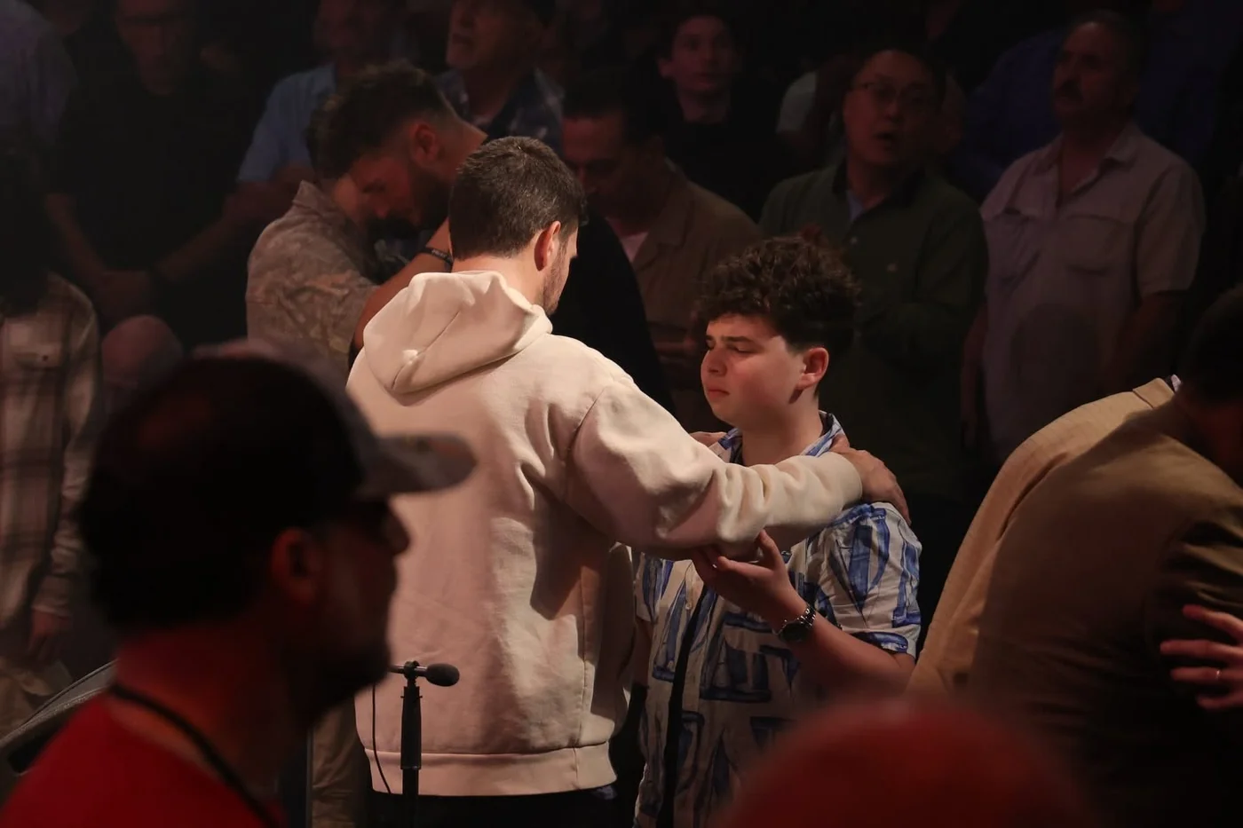 Young attendees supporting one another in prayer at the 2026 conference